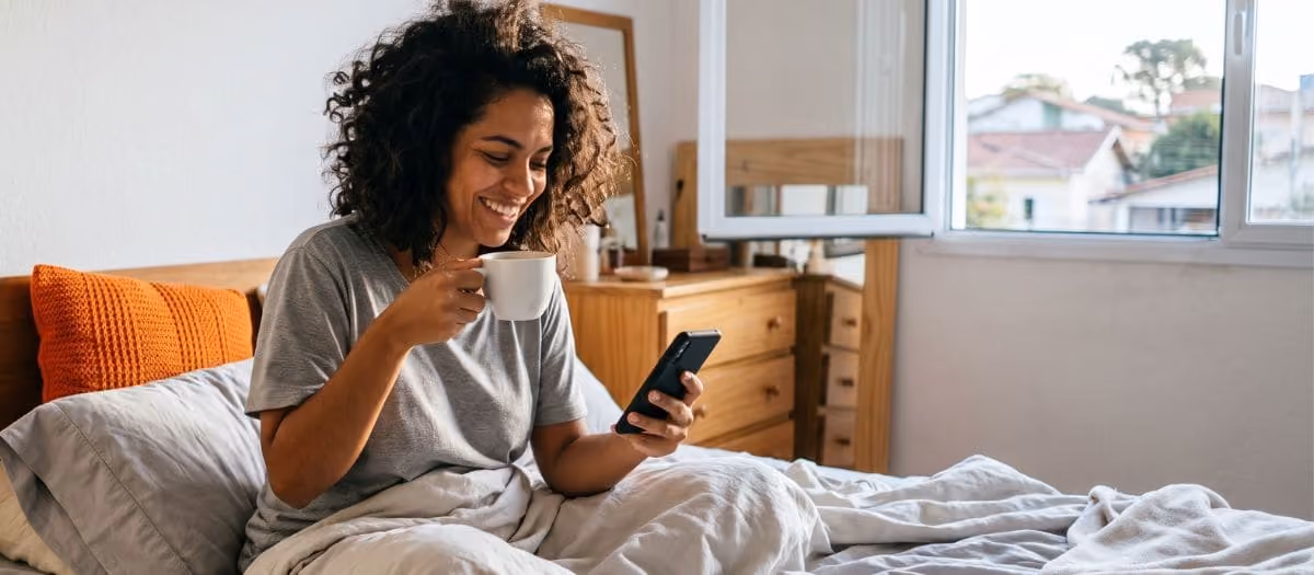 Mulher sorri ao ver o resultado da consulta do Score grátis no celular